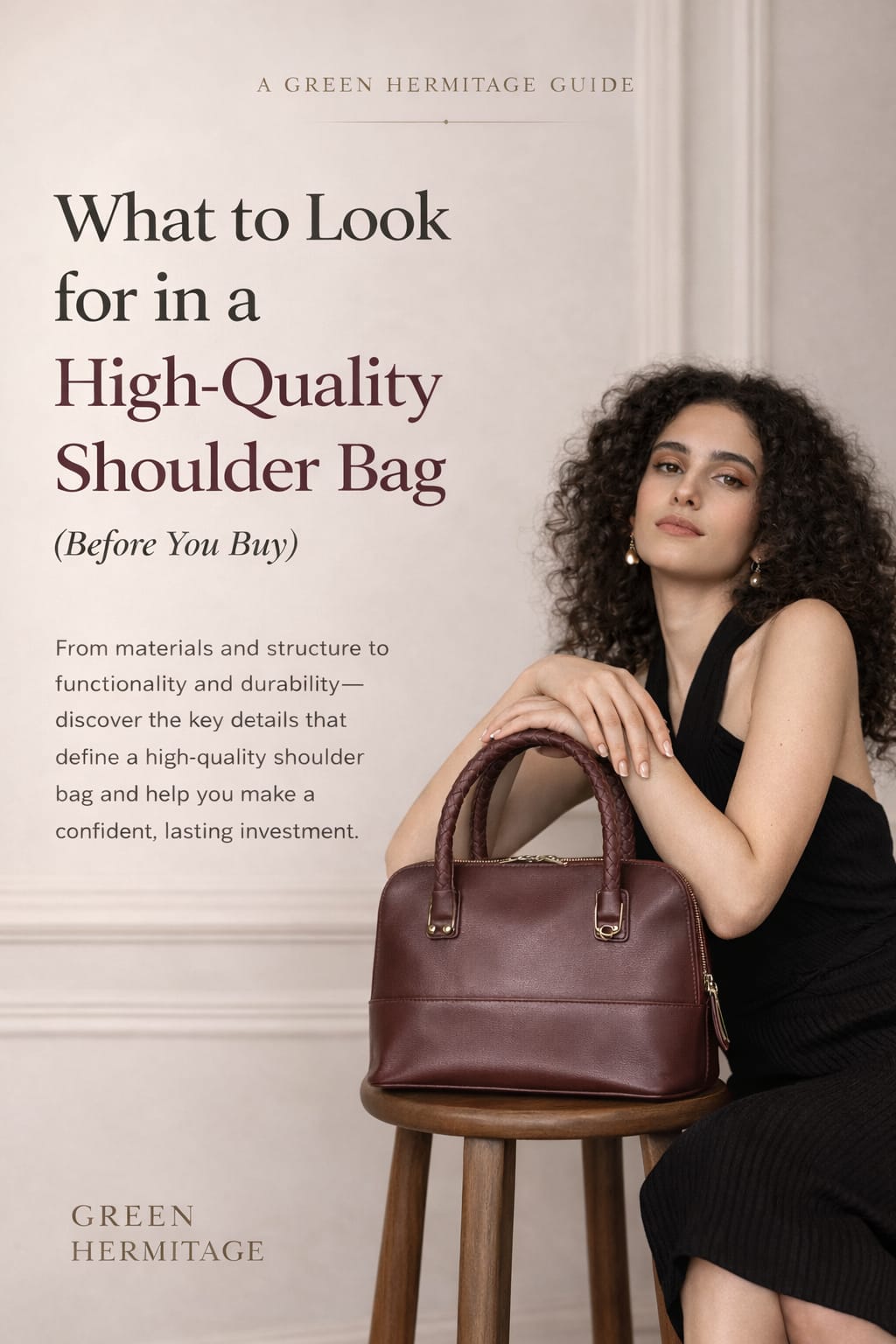 Model holding a burgundy plant leather shoulder bag in a minimal studio setting, showcasing a high-quality structured design by Green Hermitage