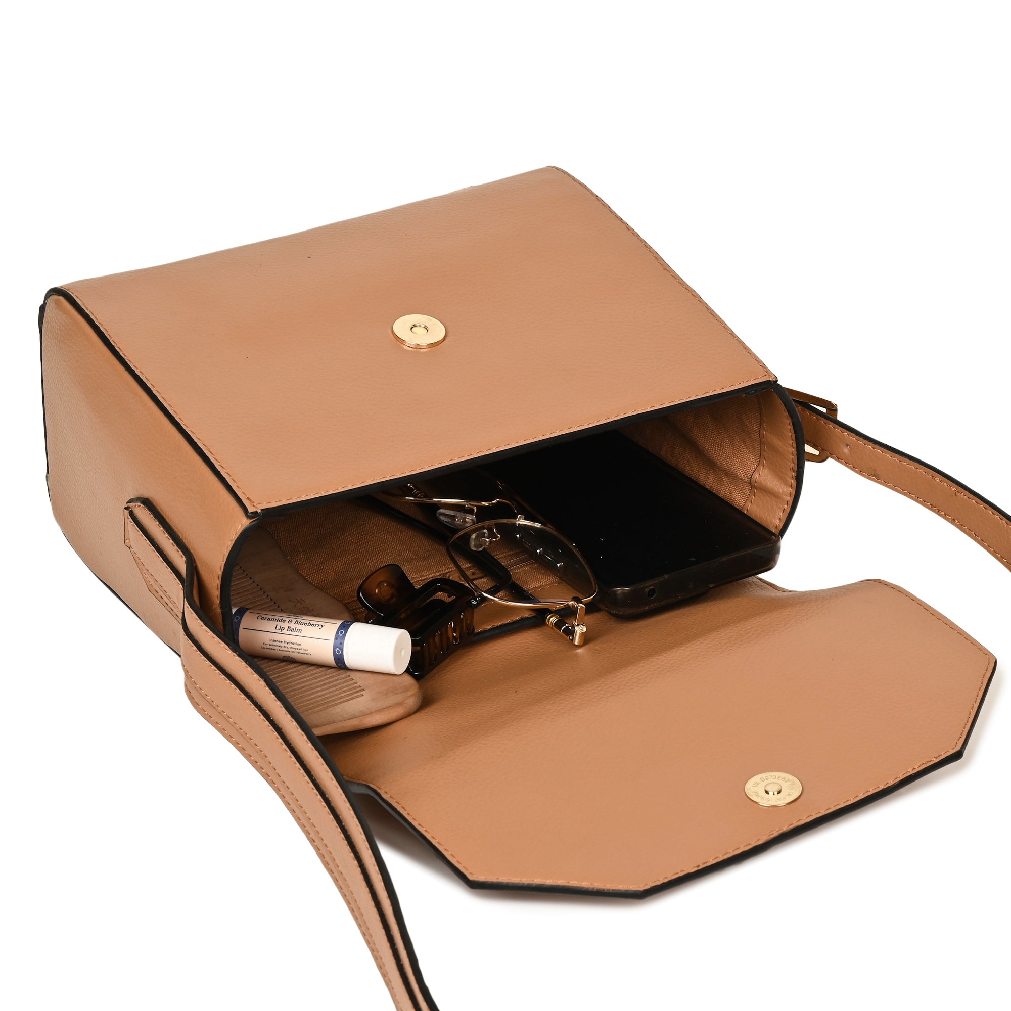 Asteria caramel vegan leather crossbody bag open showing interior compartments with essentials, highlighting storage and functionality