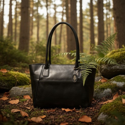 Athena black plant-based leather tote bag placed in a natural forest setting highlighting sustainable craftsmanship