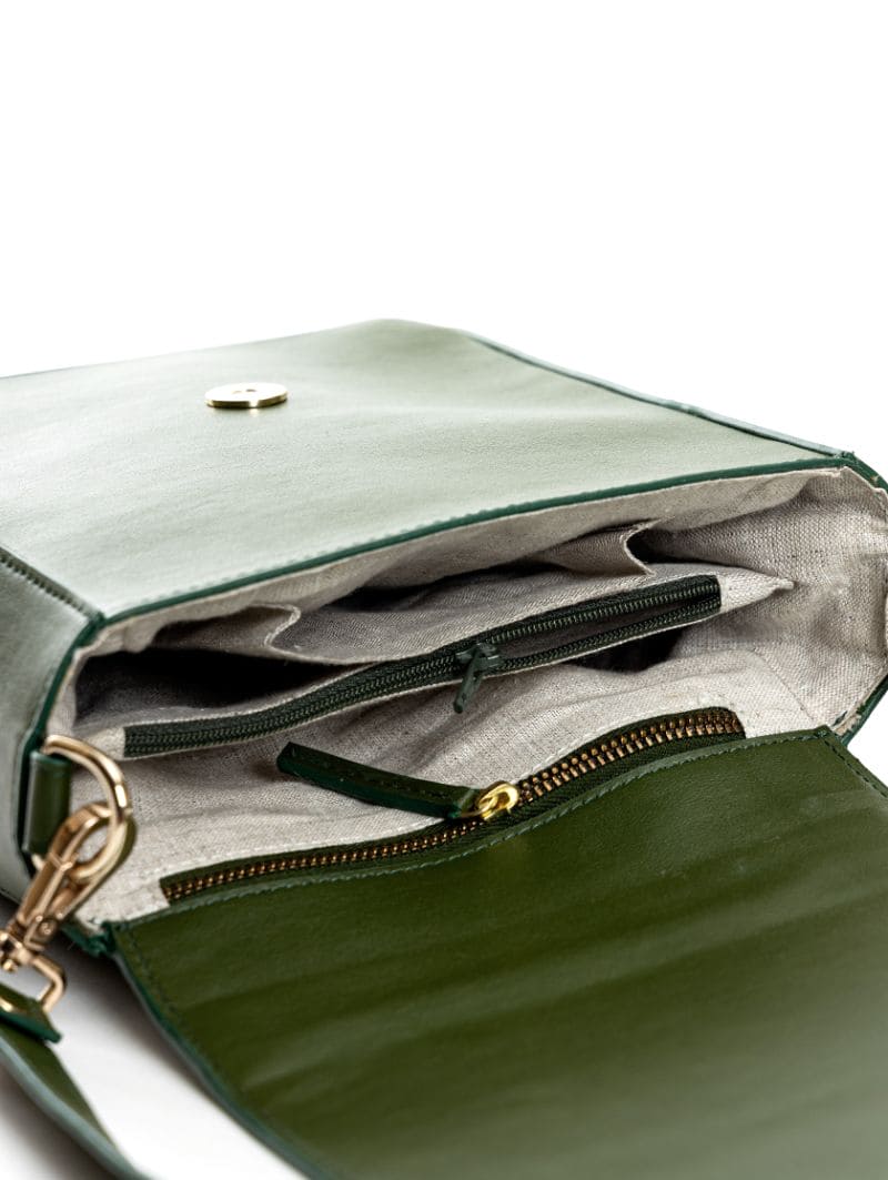 Interior view of Ceres green plant leather crossbody bag showing multiple compartments, hemp lining and zipper details