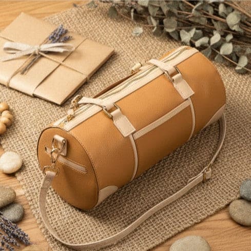 Top angle view of the Salacia plant leather bowler bag in caramel and almond with detachable shoulder strap, handcrafted from plant-based apple leather and fairtrade canvas.