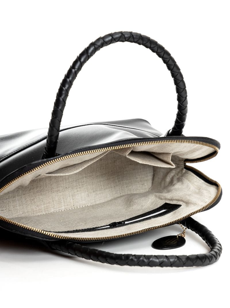 Interior view of Theia black vegan leather shoulder bag showing spacious compartment, inner zip pocket and sustainable lining