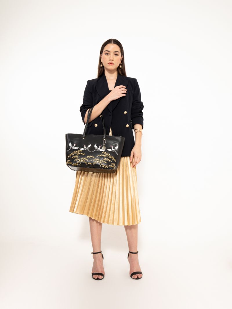 Model carrying Antheia black embroidered plant-based leather tote bag, showcasing size, structure, and elegant styling for work and everyday wear