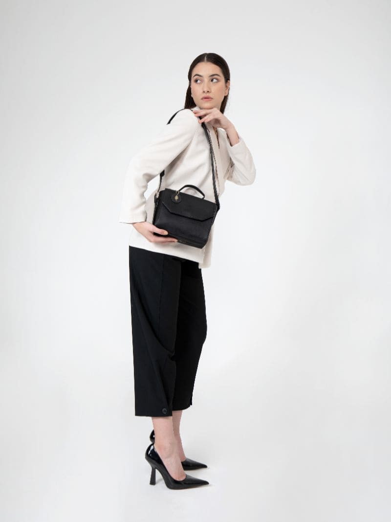 Model wearing Asteria black plant-based leather crossbody bag styled with modern outfit, showcasing size, fit, and everyday styling