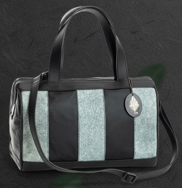 Chloris plant leather bowler bag in black and dark grey with detachable shoulder strap, handcrafted from cactus leather and Malai leather, shown in an angled front view.