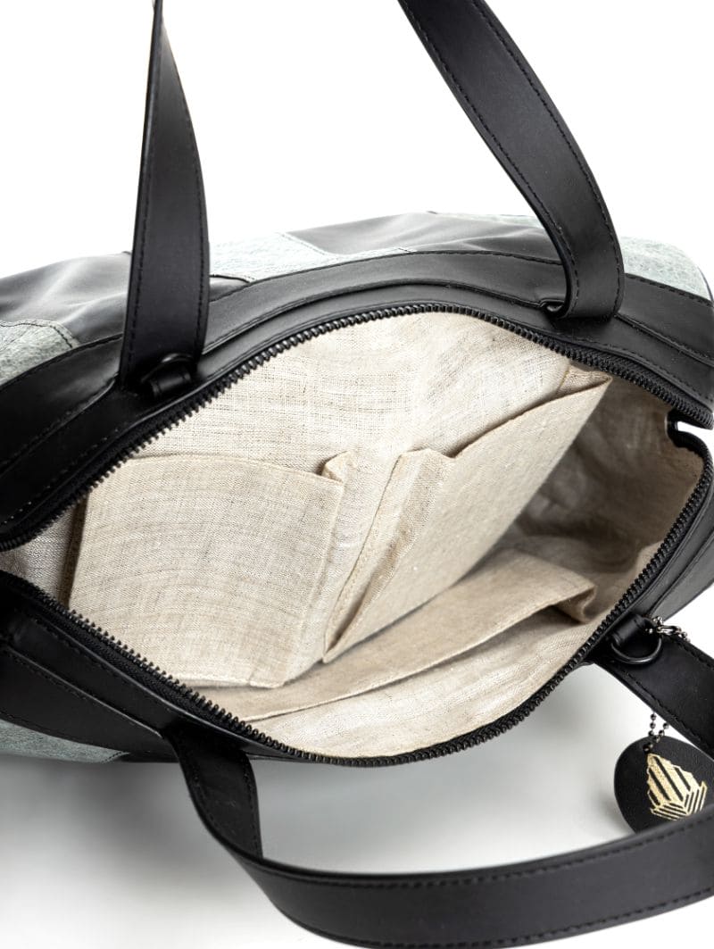 Spacious interior of the Chloris plant leather bowler bag in black and dark grey, featuring a durable fabric lining and room for everyday essentials.