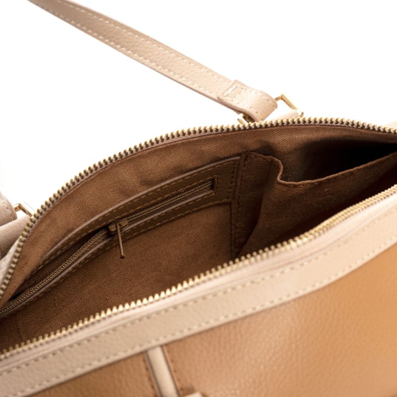 Interior view of the Salacia plant leather bowler bag in caramel and almond, featuring a spacious main compartment, secure zip pocket, and slip pockets for organized everyday essentials.
