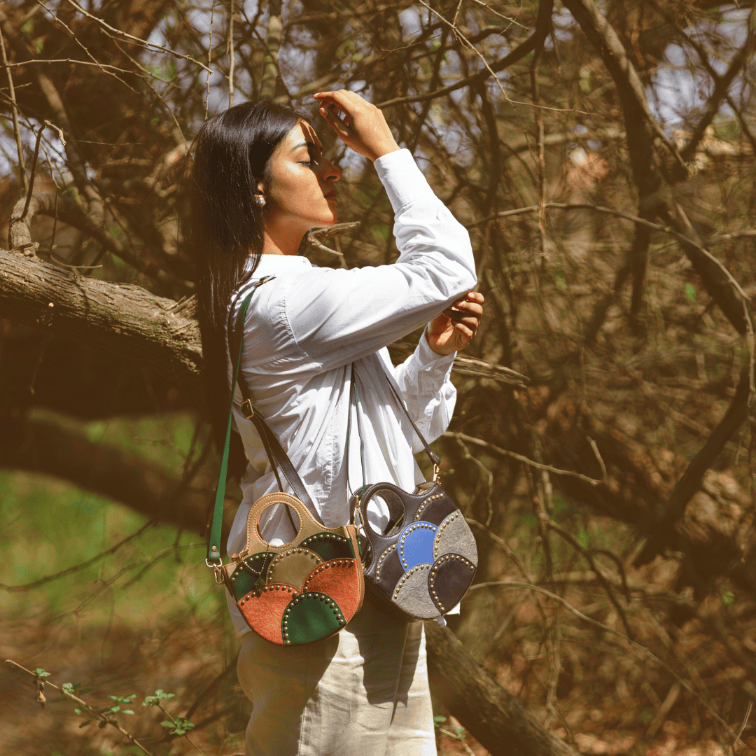 Model wearing Savannah Gold plant leather sling bag outdoors in lifestyle setting