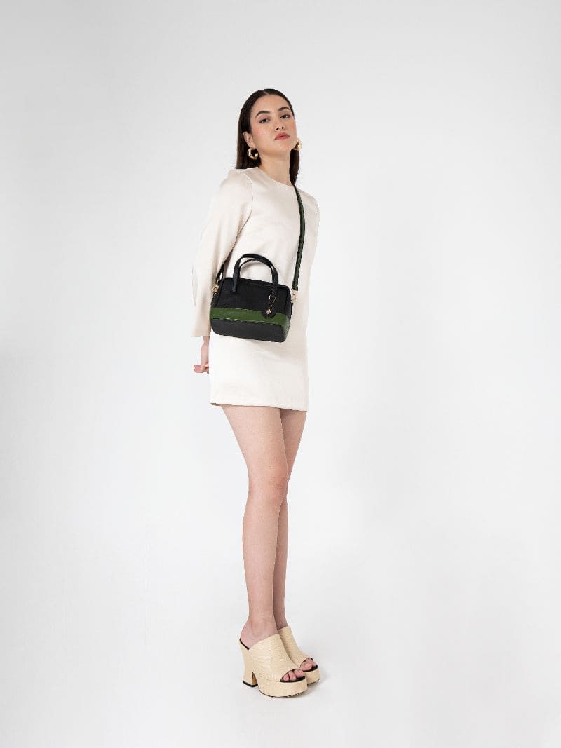 Model wearing Vanadey plant leather satchel crossbody bag in black and green styled with a neutral outfit for everyday wear
